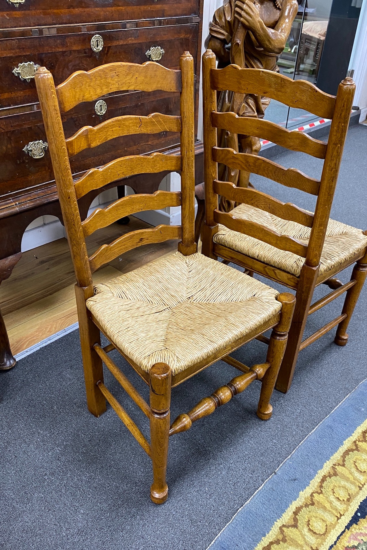 A good set of twelve reproduction Belvedere Furniture light oak ladderback dining chairs with drop in rush seats.